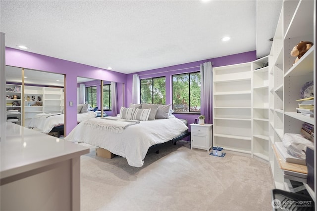 bedroom with light carpet, recessed lighting, and a textured ceiling