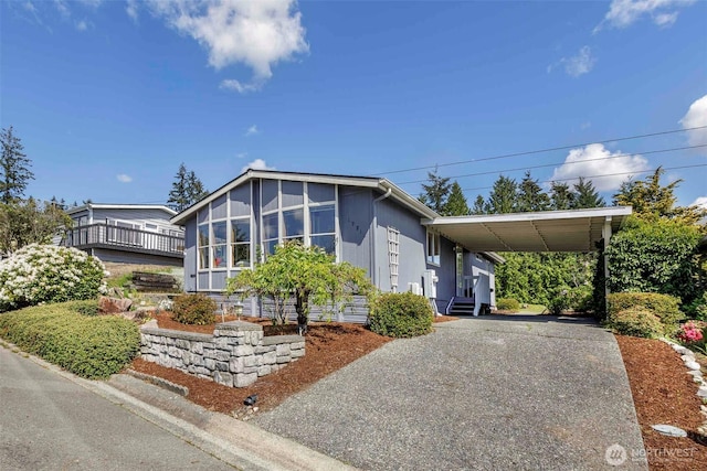 view of front of home featuring asphalt driveway and a sunroom