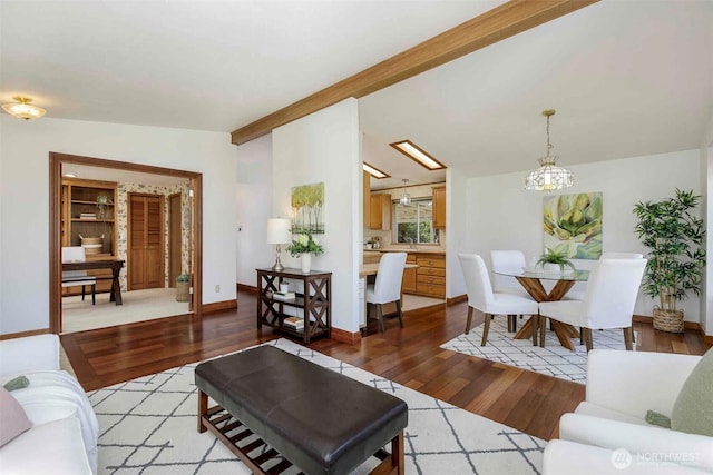 living room with light wood-style floors, a chandelier, and baseboards