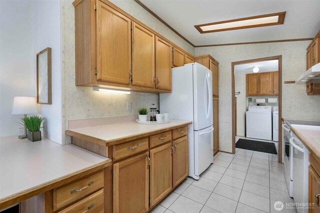 kitchen with wallpapered walls, ornamental molding, separate washer and dryer, light countertops, and light tile patterned flooring
