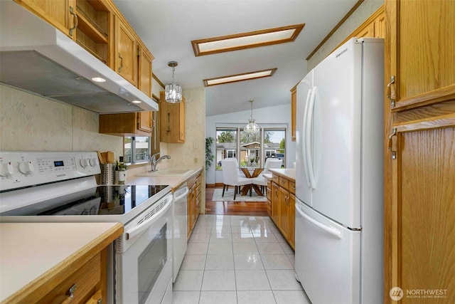 kitchen with white appliances, under cabinet range hood, light countertops, a sink, and light tile patterned flooring