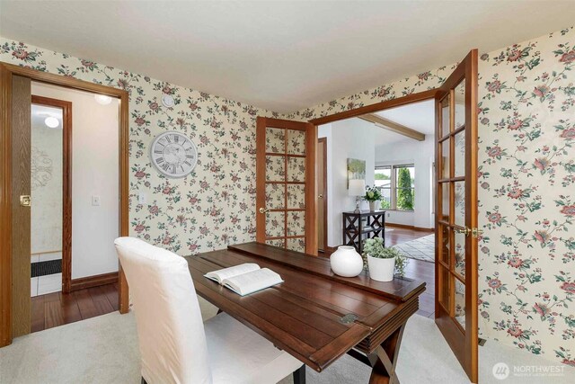 dining room featuring wallpapered walls, wood finished floors, baseboards, and a desk