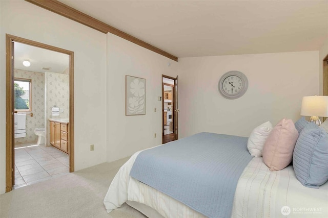 bedroom featuring light carpet and connected bathroom