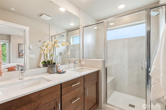 ensuite bathroom featuring plenty of natural light, a stall shower, and a sink