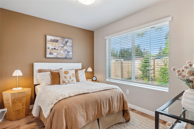 bedroom with light wood finished floors and baseboards