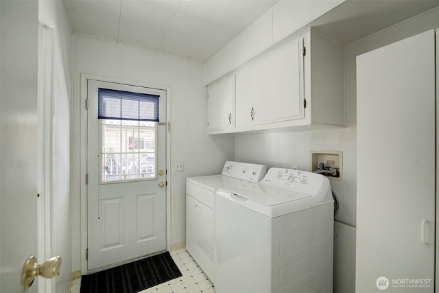 clothes washing area featuring separate washer and dryer and cabinet space