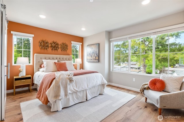 bedroom with baseboards, light wood finished floors, and recessed lighting