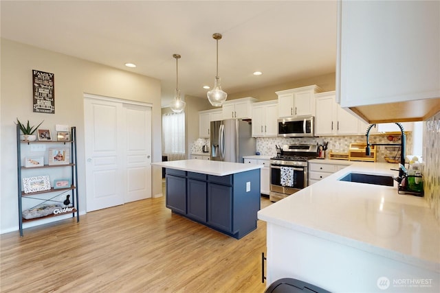 2090 Alco Ave, Walla Walla, WA 99362 - kitchen with a center island, light wood finished floors, white cabinetry, decorative backsplash, and appliances with stainless steel finishes