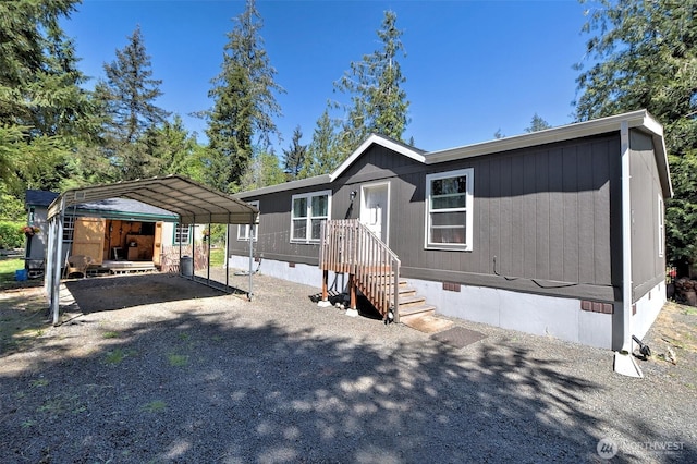 manufactured / mobile home with crawl space, a detached carport, and driveway