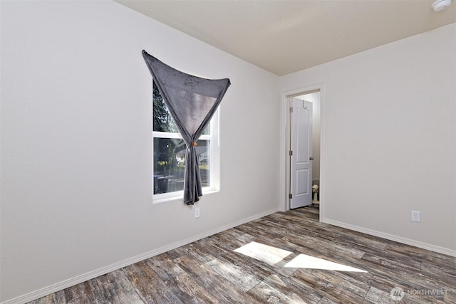 spare room featuring wood finished floors, baseboards, and a smoke detector