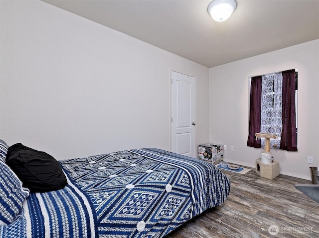 bedroom with wood finished floors and baseboards