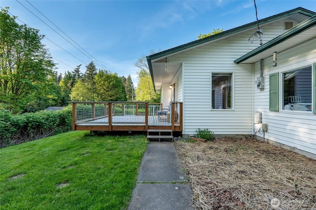 view of side of property featuring a lawn, a deck, and cooling unit