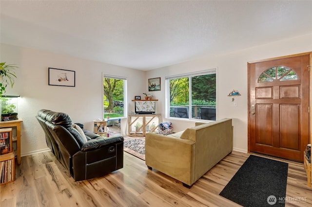 living area with light wood-style floors and baseboards