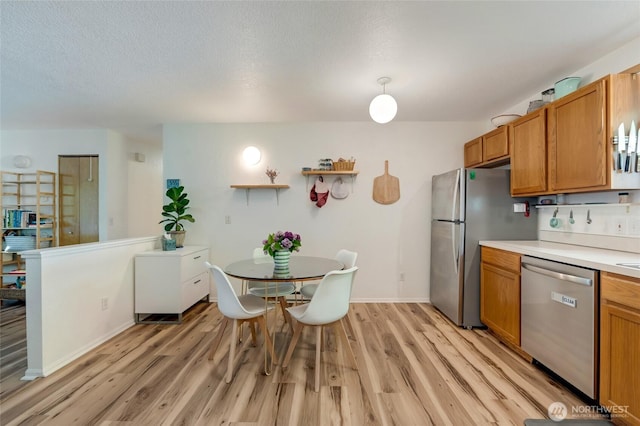kitchen featuring stainless steel dishwasher, light wood-type flooring, light countertops, brown cabinets, and a textured ceiling