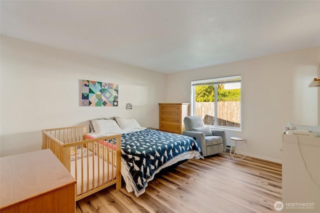 bedroom with light wood-type flooring and baseboards