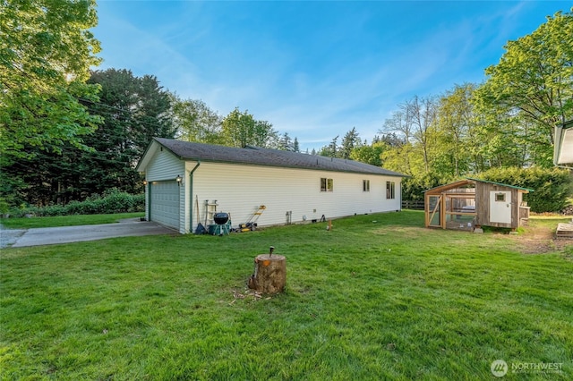 back of house with a garage, a yard, an outbuilding, and exterior structure