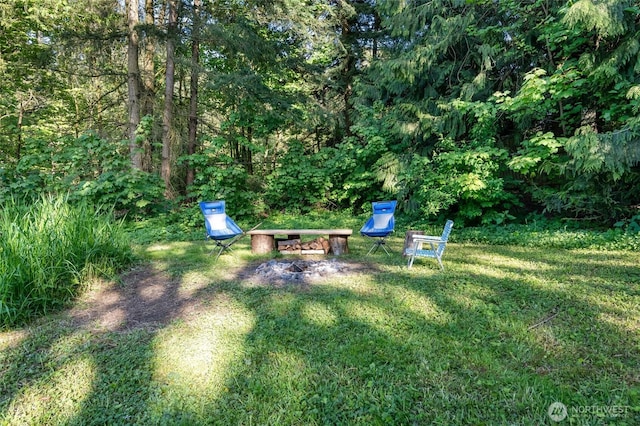 view of green lawn featuring a view of trees