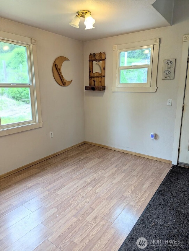 unfurnished room featuring light wood-style flooring and baseboards