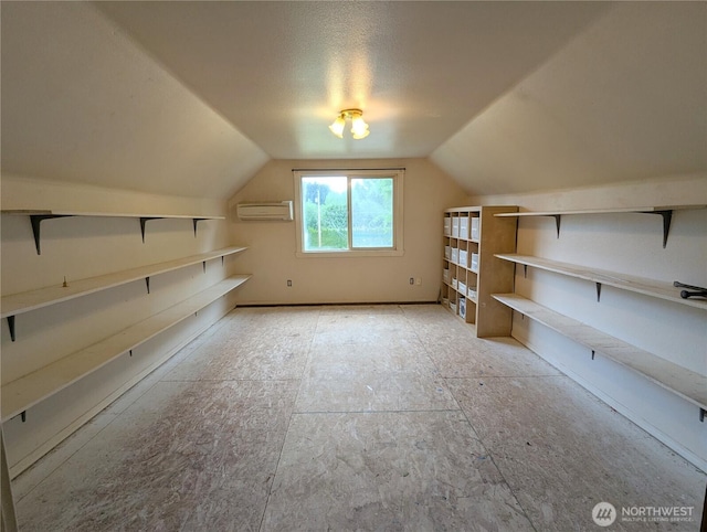 additional living space with a wall mounted AC and lofted ceiling