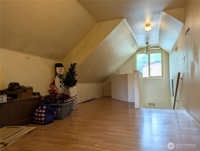 bonus room with vaulted ceiling, wood finished floors, and a ceiling fan