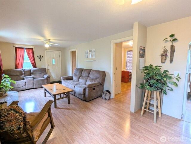living room featuring light wood-type flooring and a ceiling fan