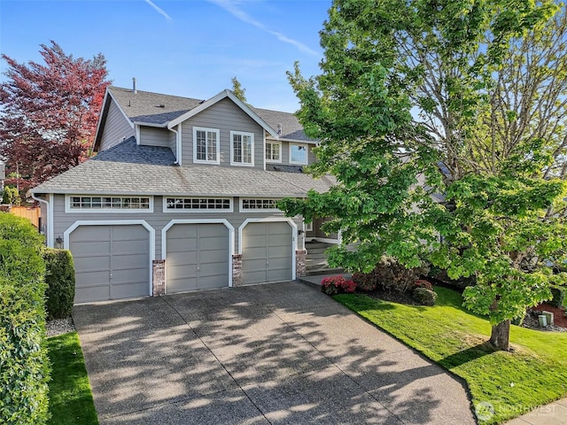 view of front of property featuring a garage, a shingled roof, and concrete driveway