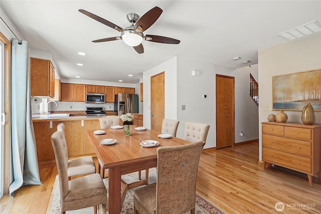 dining area featuring a ceiling fan, light wood finished floors, recessed lighting, stairs, and baseboards