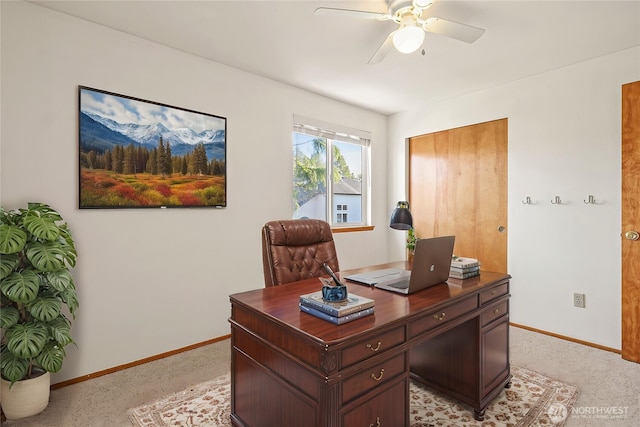 office space with a ceiling fan and baseboards
