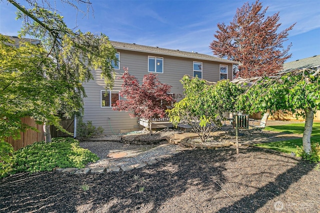 rear view of house featuring fence