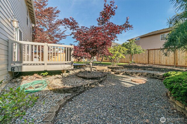 view of yard featuring a wooden deck and fence