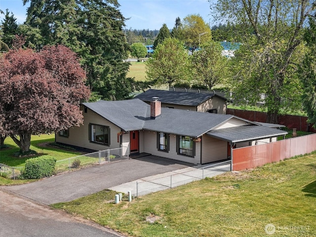 ranch-style home with driveway, a chimney, and a shingled roof