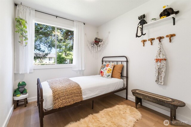 bedroom featuring wood finished floors and baseboards