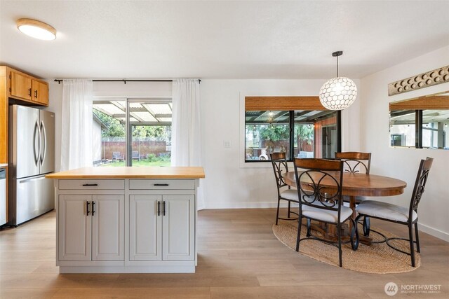dining area with light wood-style flooring and baseboards