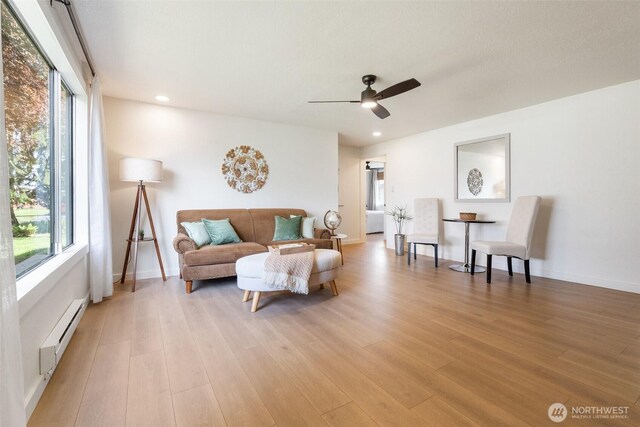 living room featuring a baseboard heating unit, ceiling fan, light wood-type flooring, healthy amount of natural light, and recessed lighting