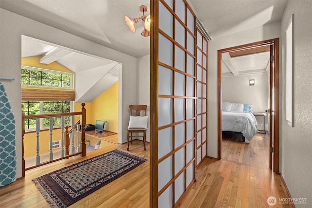 corridor with hardwood / wood-style flooring and an upstairs landing