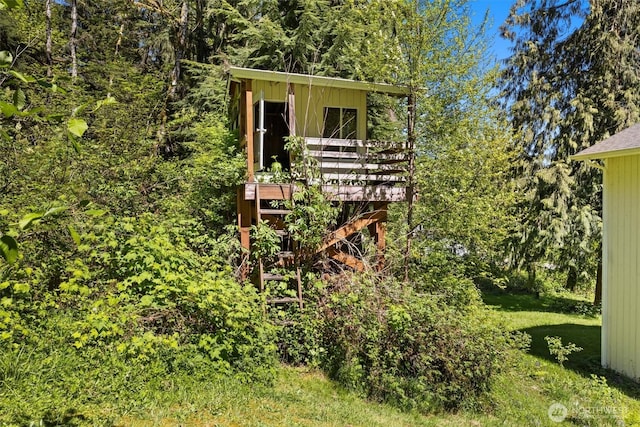 view of yard featuring a deck and a view of trees