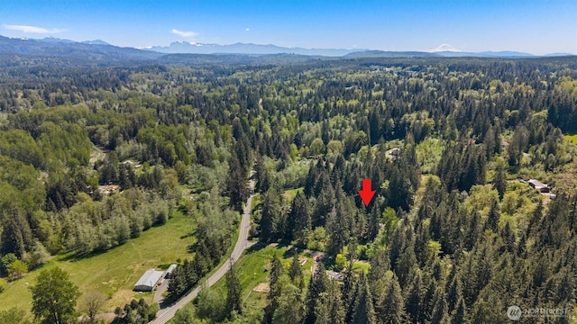 view of property location featuring a heavily wooded area and mountains