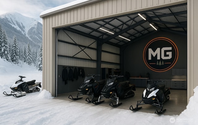 snow covered garage featuring a mountain view