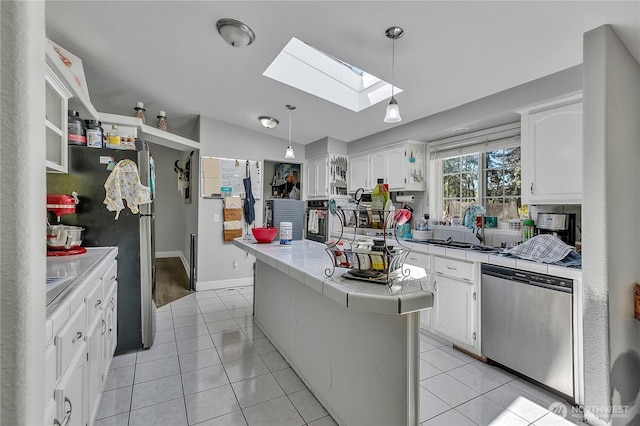 kitchen with stainless steel appliances, tile countertops, and white cabinets