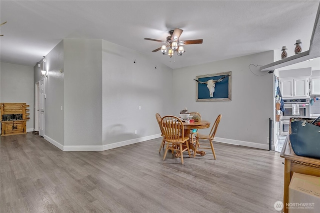dining area with ceiling fan, baseboards, and wood finished floors