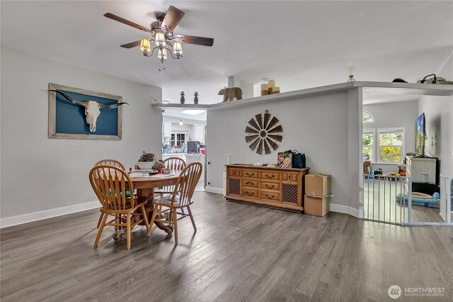 dining room with ceiling fan, baseboards, and wood finished floors