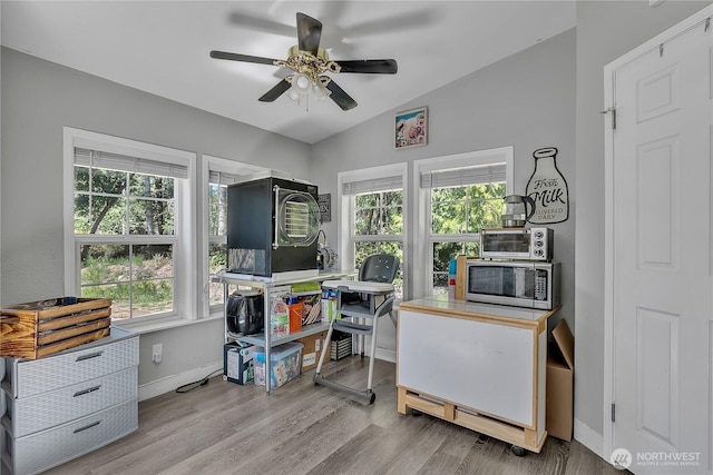 office space featuring ceiling fan, lofted ceiling, a wealth of natural light, and baseboards
