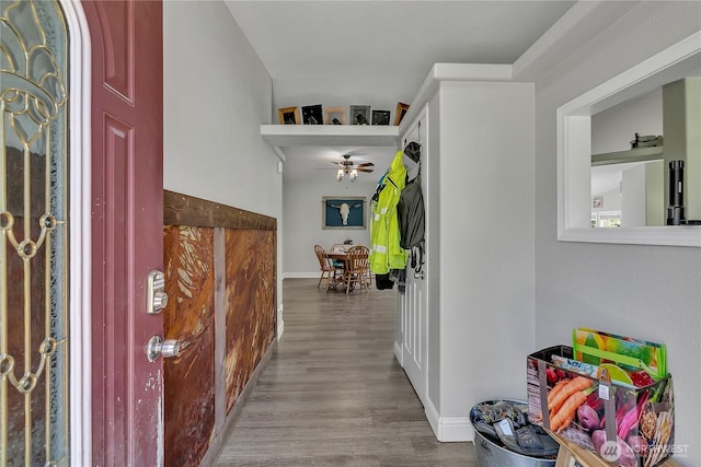 hall with baseboards and wood finished floors
