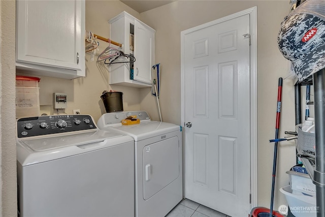 clothes washing area with cabinet space, washer and clothes dryer, and light tile patterned floors
