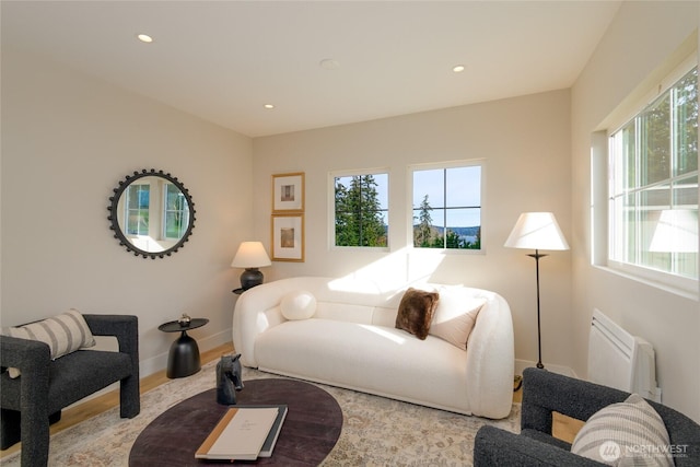 living area featuring recessed lighting, a wealth of natural light, baseboards, and radiator heating unit