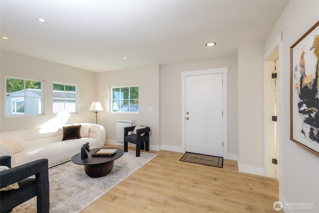 living area featuring baseboards, recessed lighting, and light wood-type flooring