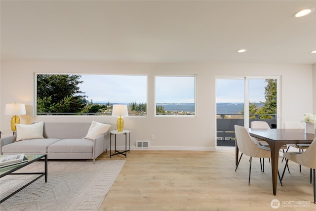 living room featuring a wealth of natural light, visible vents, and recessed lighting