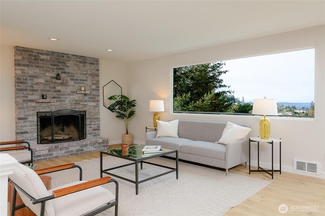 living room with wood finished floors, visible vents, recessed lighting, a fireplace, and baseboards