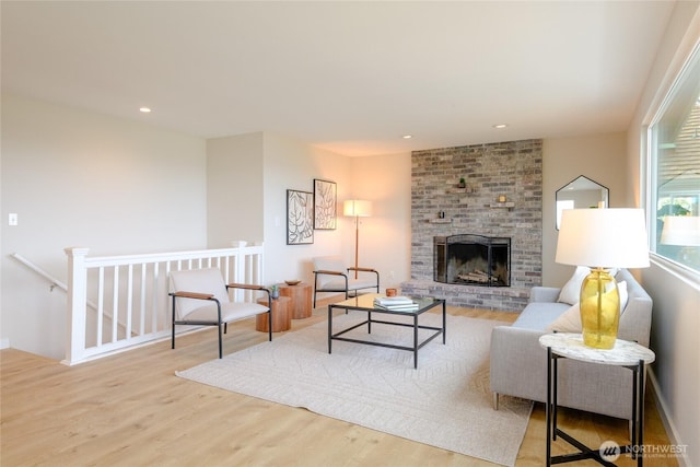 living area with wood finished floors, a fireplace, and recessed lighting