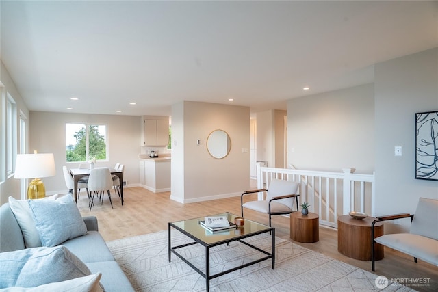 living room featuring baseboards, light wood-style floors, and recessed lighting